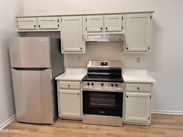 7164 Kimlee Cv, Southaven, MS 38671 - kitchen with stainless steel appliances, exhaust hood, light countertops, light wood-style flooring, and baseboards