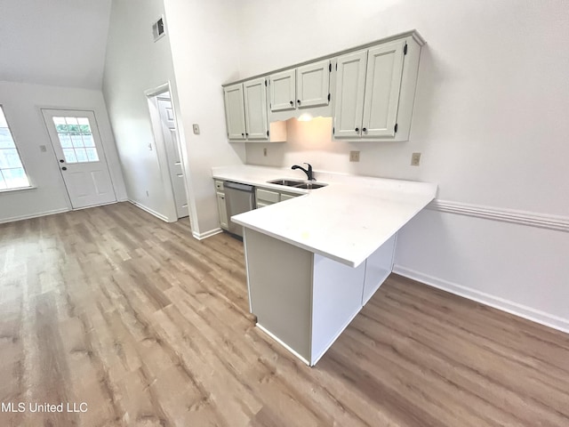 7164 Kimlee Cv, Southaven, MS 38671 - kitchen with light countertops, a sink, light wood-type flooring, stainless steel dishwasher, and high vaulted ceiling