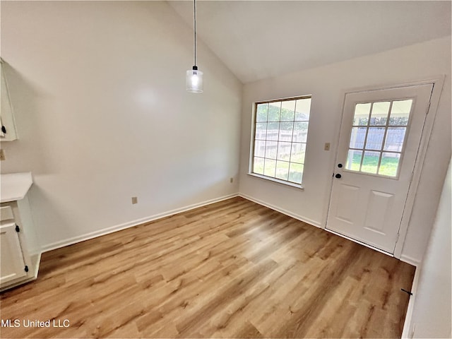 7164 Kimlee Cv, Southaven, MS 38671 - unfurnished dining area featuring light wood-style flooring, baseboards, and high vaulted ceiling