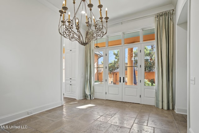 interior space featuring an inviting chandelier, crown molding, and french doors