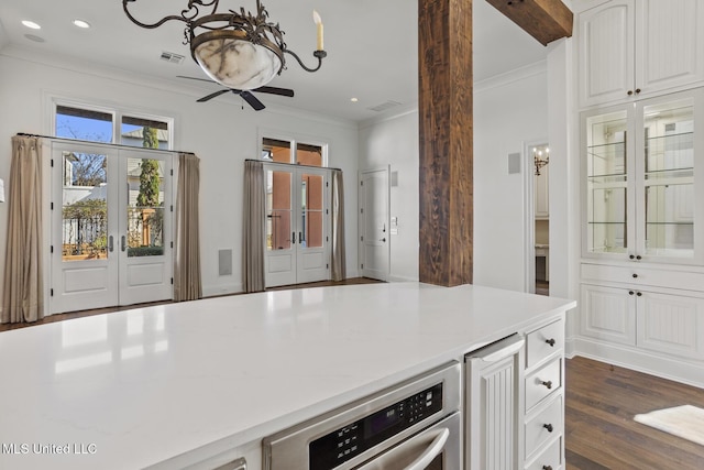 kitchen with white cabinets, ornamental molding, dark wood-type flooring, and french doors