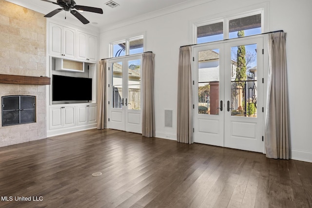 interior space featuring a large fireplace, a wealth of natural light, french doors, and ceiling fan