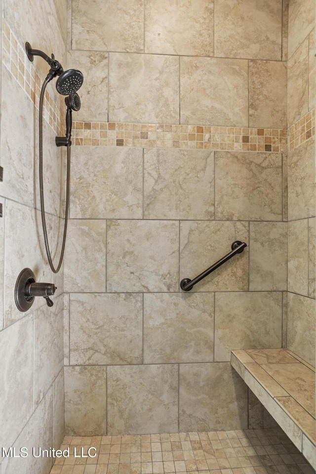 interior details featuring a tile shower