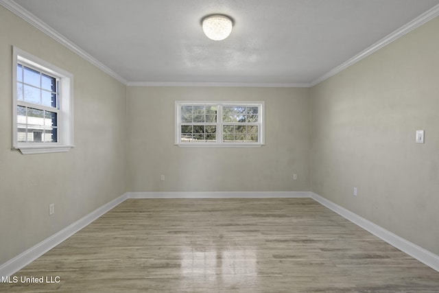 unfurnished room with light wood-type flooring, a healthy amount of sunlight, and ornamental molding