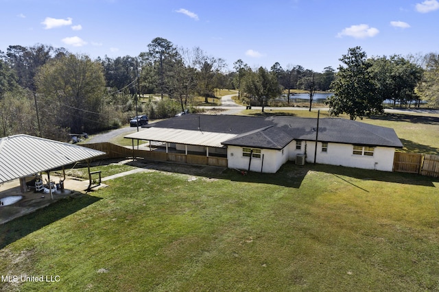 back of property with a lawn and central AC