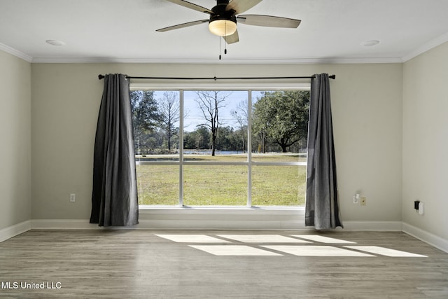 empty room featuring ceiling fan, ornamental molding, and light hardwood / wood-style flooring