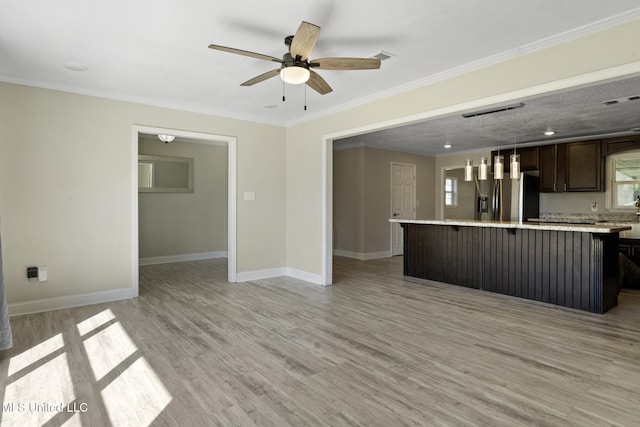 unfurnished living room with plenty of natural light, light wood-type flooring, ceiling fan, and ornamental molding