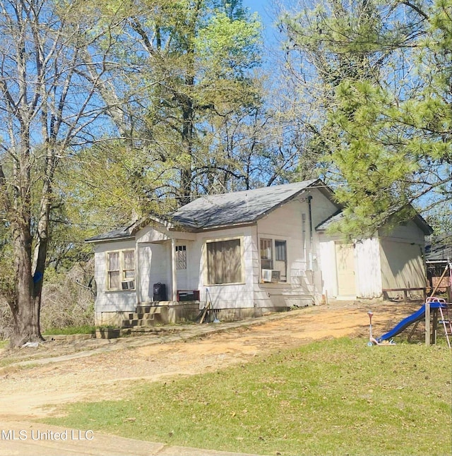 view of front of home featuring cooling unit, a playground, and a front yard