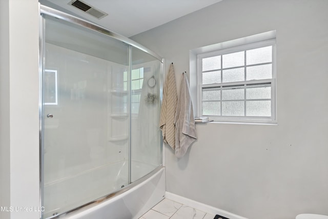 bathroom with shower / bath combination with glass door