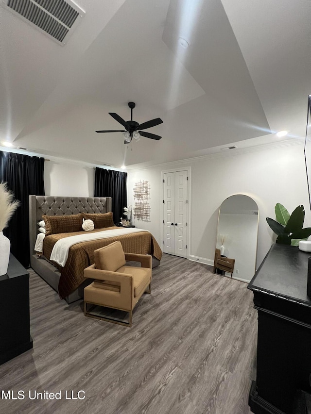 bedroom with visible vents, wood finished floors, baseboards, arched walkways, and a ceiling fan