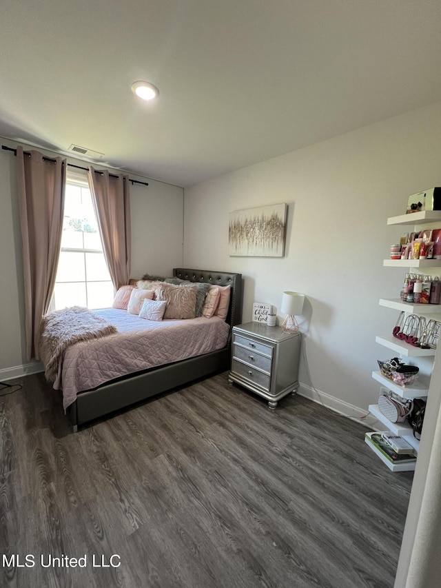 bedroom featuring baseboards, dark wood-style floors, and visible vents