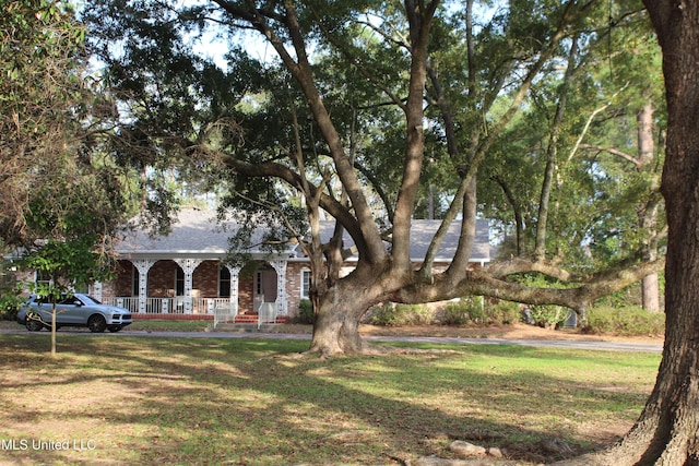 view of front facade featuring covered porch and a front yard