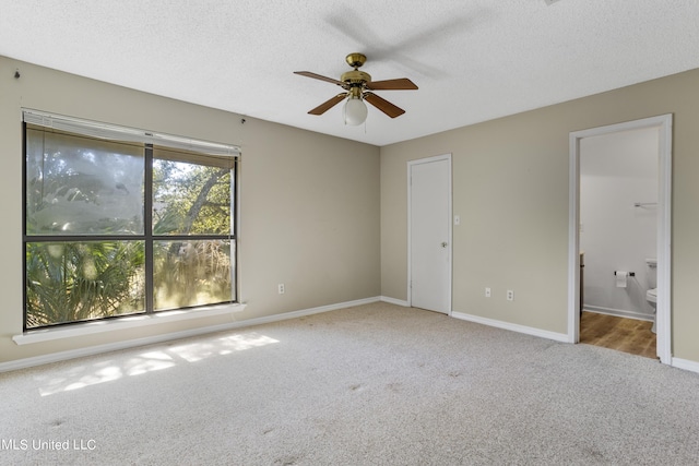 295 Highpoint Dr, Diamondhead, MS 39525 - unfurnished bedroom with baseboards, carpet floors, a textured ceiling, and ensuite bathroom