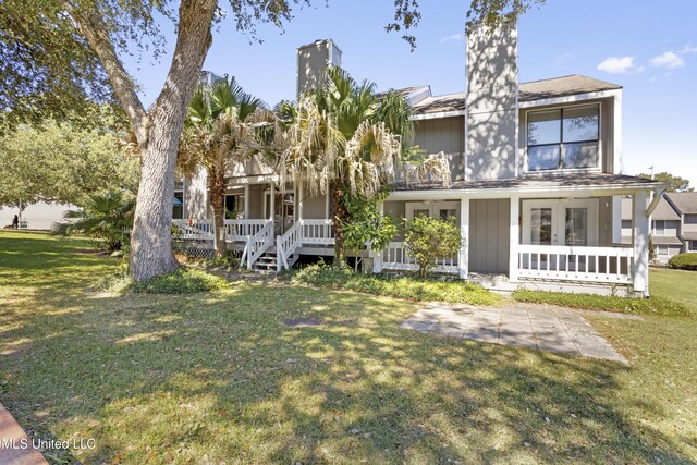 295 Highpoint Dr, Diamondhead, MS 39525 - view of front of home with a front yard, french doors, covered porch, and a chimney