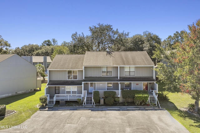 295 Highpoint Dr, Diamondhead, MS 39525 - view of front of property with a porch, a front yard, a shingled roof, and stairway
