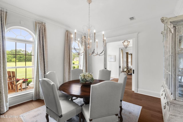 1053 Woodbridge Dr, Brandon, MS 39047 - dining space featuring a chandelier, healthy amount of natural light, wood finished floors, crown molding, and baseboards