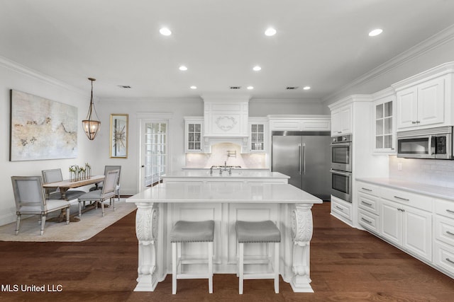 1053 Woodbridge Dr, Brandon, MS 39047 - kitchen featuring appliances with stainless steel finishes, a kitchen island, light countertops, decorative backsplash, and crown molding