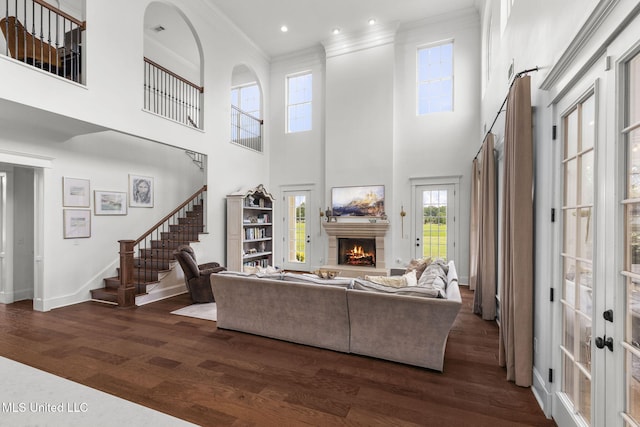 1053 Woodbridge Dr, Brandon, MS 39047 - living area featuring crown molding, a lit fireplace, dark wood-type flooring, baseboards, and a towering ceiling