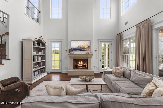 1053 Woodbridge Dr, Brandon, MS 39047 - living room with a high ceiling, a lit fireplace, wood finished floors, plenty of natural light, and stairway