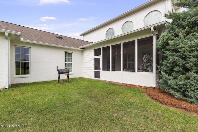 1053 Woodbridge Dr, Brandon, MS 39047 - back of house featuring a sunroom, a lawn, a shingled roof, and brick siding