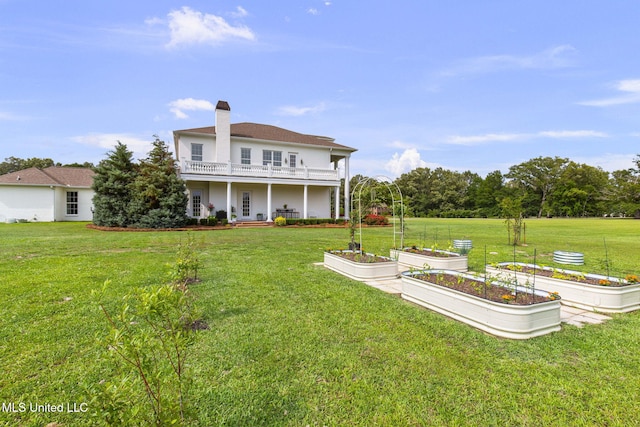 1053 Woodbridge Dr, Brandon, MS 39047 - back of house with a garden, a yard, and a balcony