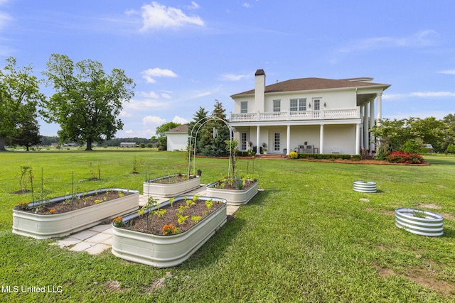 1053 Woodbridge Dr, Brandon, MS 39047 - back of house featuring a garden, a yard, a balcony, and a chimney