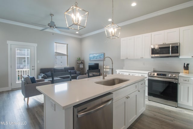 kitchen with a center island with sink, appliances with stainless steel finishes, light countertops, and a sink