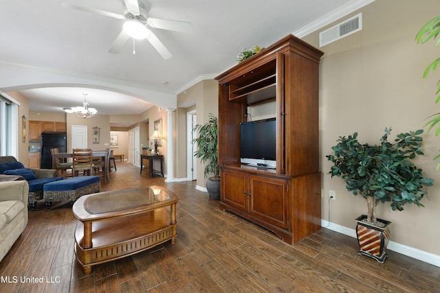 living room with dark wood-type flooring, ceiling fan, crown molding, and decorative columns