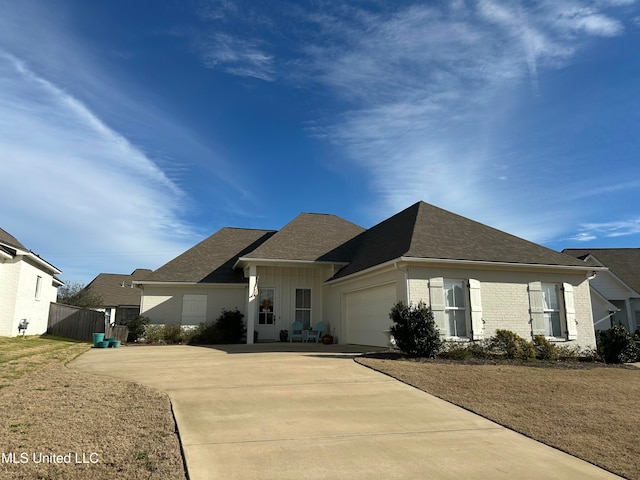 ranch-style house featuring an attached garage, brick siding, fence, driveway, and board and batten siding