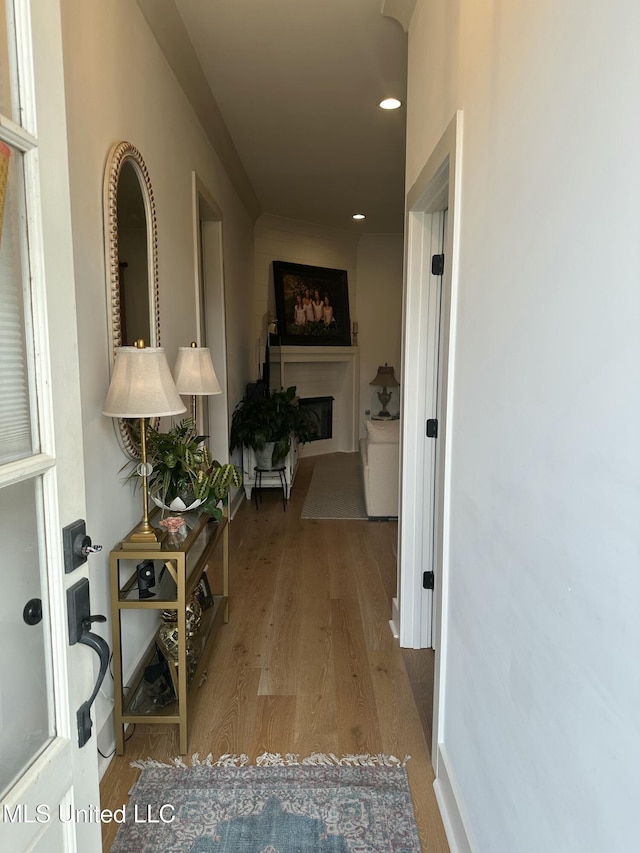 hall featuring baseboards, wood finished floors, and recessed lighting