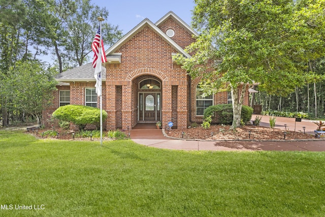 5578 E Diamondhead Dr, Diamondhead, MS 39525 - view of front of home featuring brick siding, a front yard, and a shingled roof