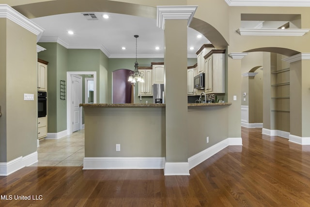 5578 E Diamondhead Dr, Diamondhead, MS 39525 - kitchen featuring arched walkways, a peninsula, oven, stainless steel fridge, and light wood-style floors