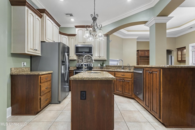 5578 E Diamondhead Dr, Diamondhead, MS 39525 - kitchen with appliances with stainless steel finishes, a center island with sink, light stone counters, crown molding, and a sink