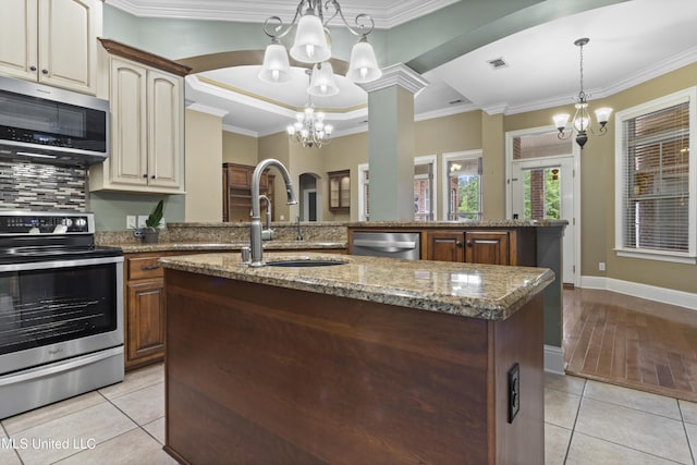 5578 E Diamondhead Dr, Diamondhead, MS 39525 - kitchen featuring stainless steel appliances, a chandelier, a sink, light tile patterned flooring, and a center island with sink