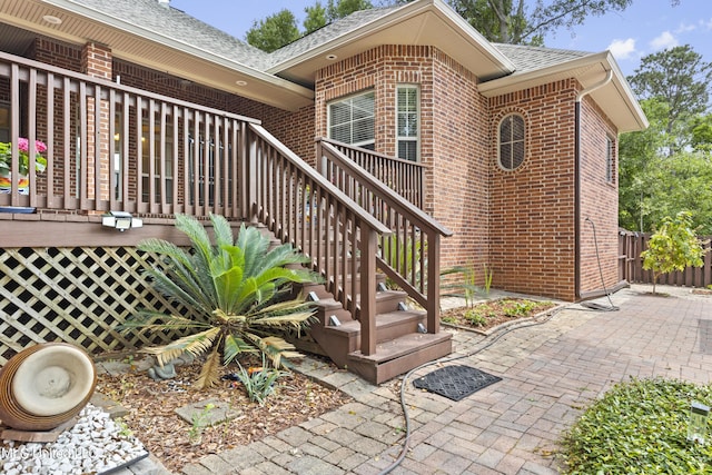 5578 E Diamondhead Dr, Diamondhead, MS 39525 - view of exterior entry with brick siding, a shingled roof, and a patio