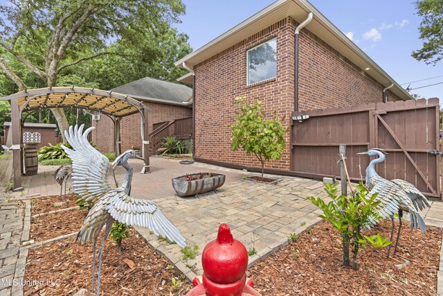5578 E Diamondhead Dr, Diamondhead, MS 39525 - view of patio featuring a fire pit and a gate