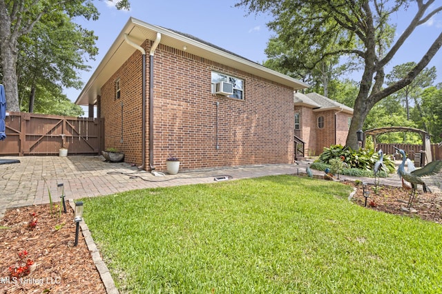 5578 E Diamondhead Dr, Diamondhead, MS 39525 - rear view of property featuring brick siding, a gate, a patio area, and cooling unit