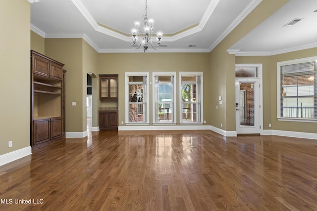 5578 E Diamondhead Dr, Diamondhead, MS 39525 - unfurnished living room with a raised ceiling, dark wood-style floors, a chandelier, arched walkways, and ornamental molding