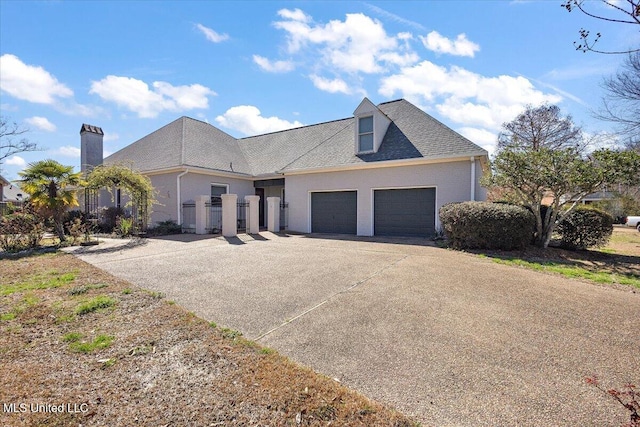 view of front of home with a garage, roof with shingles, and driveway