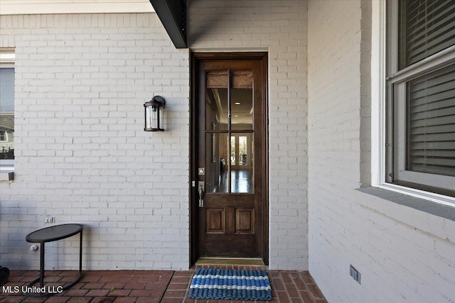 doorway to property with brick siding