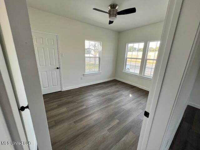 spare room with dark hardwood / wood-style flooring and ceiling fan