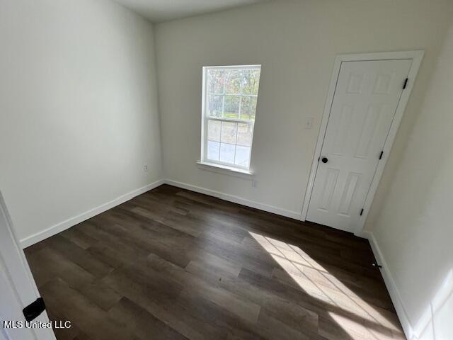 unfurnished room with dark hardwood / wood-style flooring