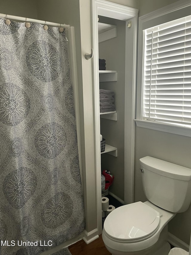 full bathroom featuring toilet and a shower with shower curtain