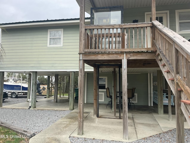 rear view of property with a carport and a patio area