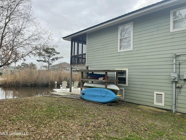 view of side of home with metal roof and a patio