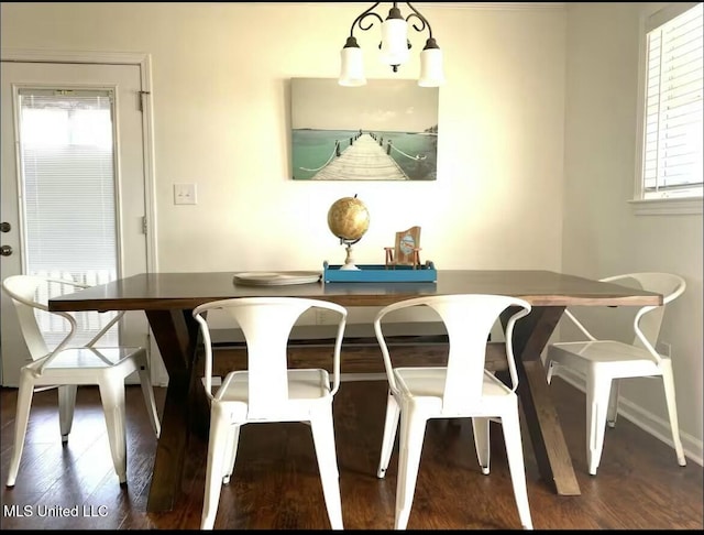 dining space featuring an inviting chandelier, baseboards, and wood finished floors