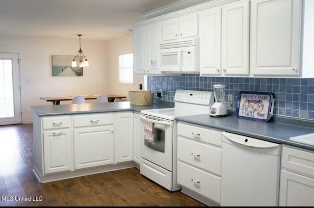 kitchen with a peninsula, white appliances, dark wood-style floors, and white cabinets