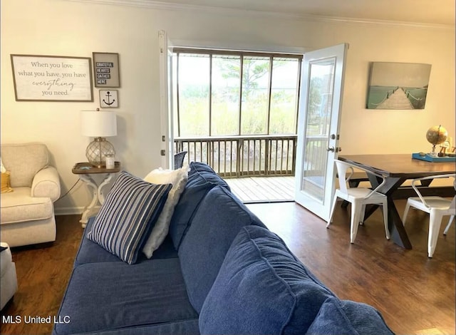 living area with baseboards, crown molding, and wood finished floors