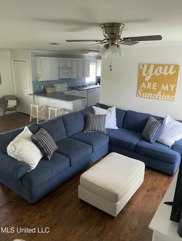 living room featuring visible vents, dark wood finished floors, and a ceiling fan