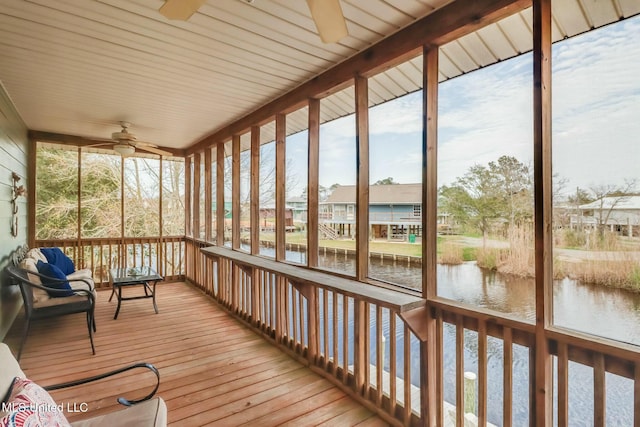 unfurnished sunroom featuring a water view and ceiling fan